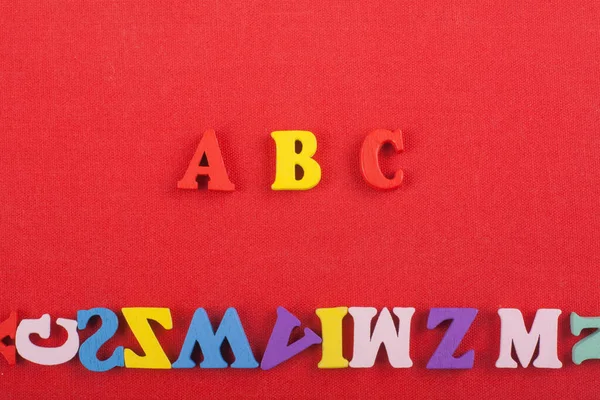 红色背景上的字由彩色方块拼成的木制字母组成 复制广告文字的空间 学习英语概念 — 图库照片