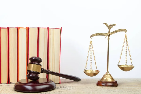 Law concept - Open law book, Judge\'s gavel, scales, Themis statue on table in a courtroom or law enforcement office. Wooden table, white background.