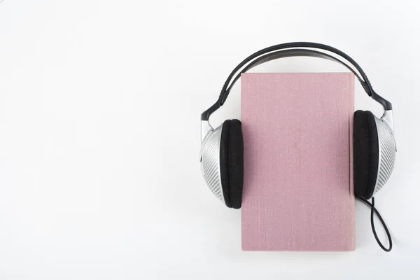 Аудиокнига Белом Фоне Наушники Надели Розовую Книгу Твёрдом Переплете Пустую — стоковое фото