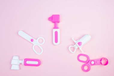 Çocuk tıbbi aletleri. Çocuk doktoru konsepti. Pediyatri. Pembe arka planda oyuncak tıbbi cihazlar. Meslek seçimi. Aşı ol.