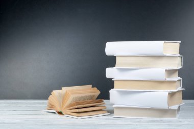 Açık siyah ve Whitel kitaplar ahşap masa, siyah tahta arka plan üzerinde. Okula dönüş. Eğitim iş kavramı