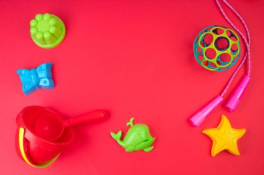 Çok renkli çocuk oyuncakları. Kırmızı bir arkaplanda.