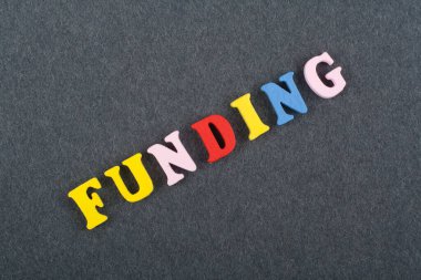 Kara tahta arka plan üzerinde kelime finansman renkli abc alfabe blok ahşap harfler, reklam metni için kopya alanı üzerinden oluşur. Öğrenme İngilizce kavramı