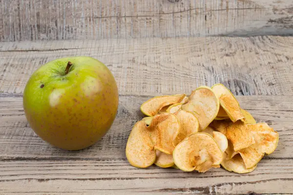Homemade organic sliced, dried apples, fresh juicy apples on wooden background