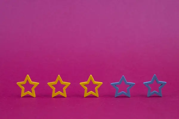Gold, gray, silver five stars shape on a purple background. The best excellent business services rating customer experience concept. Concept image of setting a five star goal.