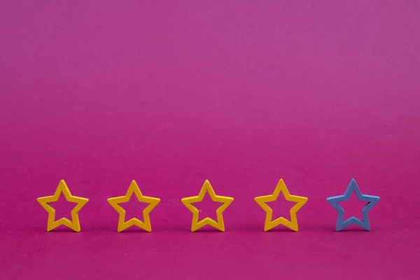 Gold, gray, silver five stars shape on a purple background. The best excellent business services rating customer experience concept. Concept image of setting a five star goal.