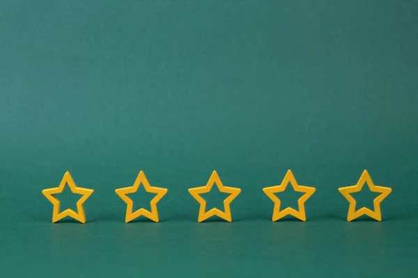 Gold, gray, silver five stars shape on a green background. The best excellent business services rating customer experience concept. Concept image of setting a five star goal.