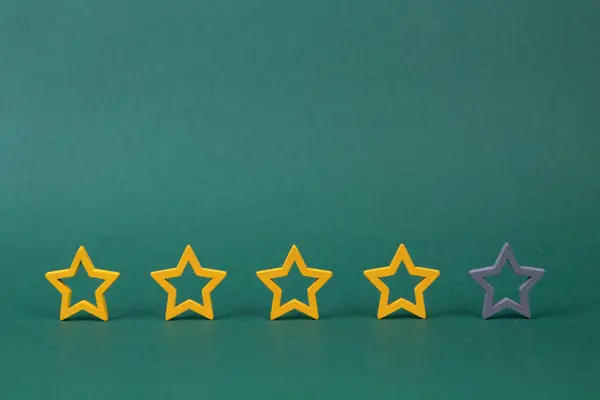 Gold, gray, silver five stars shape on a green background. The best excellent business services rating customer experience concept. Concept image of setting a five star goal.