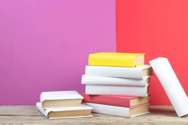 Books stacking. Books on wooden table and red, purple background. Back to school. Copy space for ad text