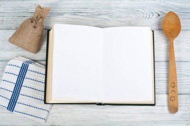 Tarifi ahşap arka plan, kaşık, oklava, damalı masa örtüsü üzerinde yemek boş kitap.