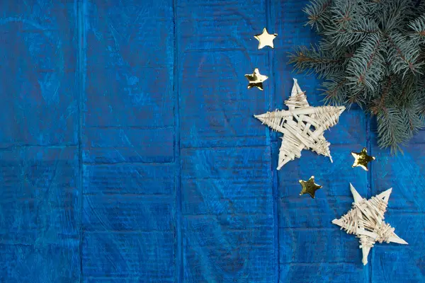 Christmas background. gold stars decorations on blue wooden background. Top view copy space. Snow frame.