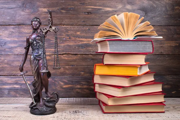 Law concept - Open law book, Judge\'s gavel, scales, Themis statue on table in a courtroom or law enforcement office. wooden background.
