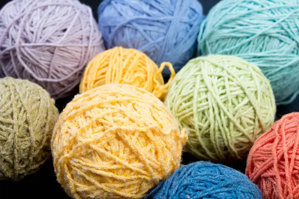 Colored yarn. Skeins of wool yarn for knitting. Balls of wool of different colours for handmade knitting on a wooden background with copy space for ad