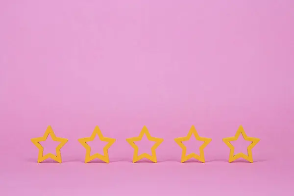 Gold, gray, silver five stars shape on a pink background. The best excellent business services rating customer experience concept. Concept image of setting a five star goal.
