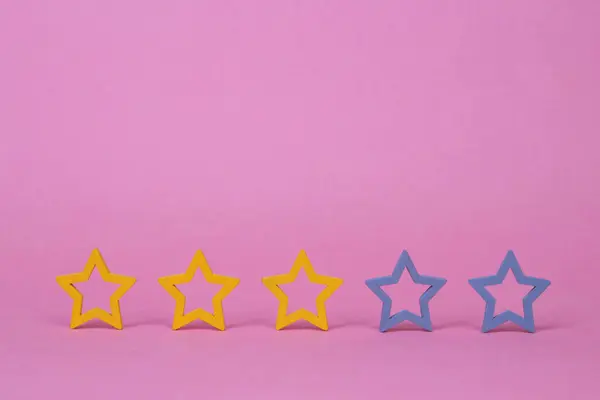 Gold, gray, silver five stars shape on a pink background. The best excellent business services rating customer experience concept. Concept image of setting a five star goal.