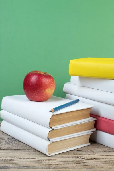 Books stacking. Books on wooden table and green background. Back to school. Copy space for ad text