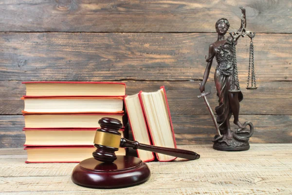 Law concept - Open law book, Judge\'s gavel, scales, Themis statue on table in a courtroom or law enforcement office. wooden background.