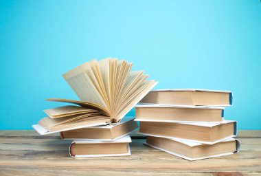 Açık bir kitap, mavi arka planda kitaplar. Okula dönelim. Eğitim. Metin için alanı kopyala