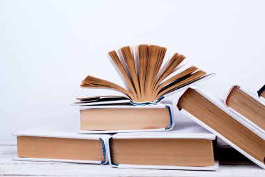 Açık kitaplar, ahşap masada ciltli renkli kitaplar. turuncu arka plan. Okula dönelim. Uzayı metin için kopyala. Eğitim sektörü kavramı