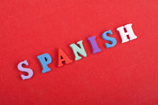 SPANISH word on red background composed from colorful abc alphabet block wooden letters, copy space for ad text. Learning english concept