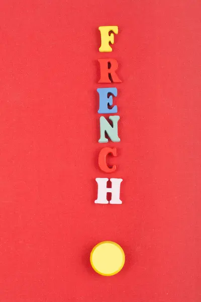 FRENCH word on red background composed from colorful abc alphabet block wooden letters, copy space for ad text. Learning english concept