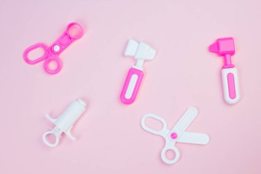 Çocuk tıbbi aletleri. Çocuk doktoru konsepti. Pediyatri. Pembe arka planda oyuncak tıbbi cihazlar. Meslek seçimi. Aşı ol.