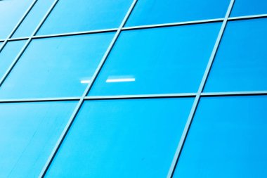 Cilalı cephe. Mavi bir arka planda donuk bir cephe. Şehir merkezinin modern gökdelenleri