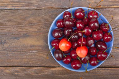 Çeşitli taze kiraz bir kase rustik ahşap masa üzerinde yaz. Antioksidan, detoks diyet, organik meyve.