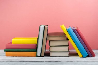 Kitap istifleme. Açık kitap, ahşap masa ve mavi arka plan üzerine ciltli kitaplar. Okula dönelim. Metin için alanı kopyala