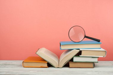 Açık kitap, ahşap masa üzerinde renkli ciltli kitap. Büyüteç'i. Okula dönüş. Metin için yer kopyalayın. Eğitim iş kavramı