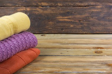 Örgü yün kazaklar. Ahşap arka planda örülmüş yaz kıyafetleri, kazaklar, örgü giysileri, metin için yer