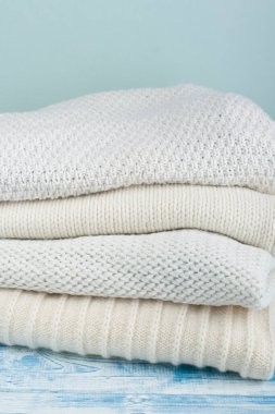 Örgü yün kazaklar. Ahşap arka planda örülmüş kış kıyafetleri, kazaklar, örgü giysileri, metin için yer.