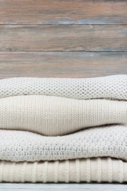 Örgü yün kazaklar. Ahşap arka planda örülmüş kış kıyafetleri, kazaklar, örgü giysileri, metin için yer.