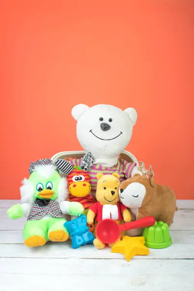Collection of colorful toys on an orange background. Kids toys