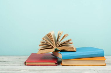 Açık kitap, ahşap masa üzerinde renkli ciltli kitap. Okula dönüş. Metin için yer kopyalayın. Eğitim iş kavramı