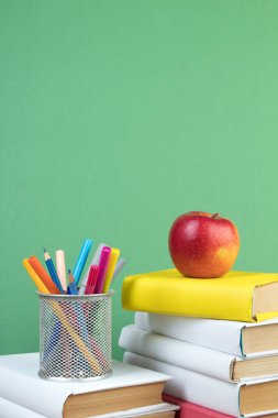 Kitaplar istifleniyor. Tahta masadaki kitaplar ve yeşil arka plan. Okula dönelim. Reklam metni için alanı kopyala