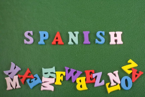SPANISH word on green background composed from colorful abc alphabet block wooden letters, copy space for ad text. Learning english concept