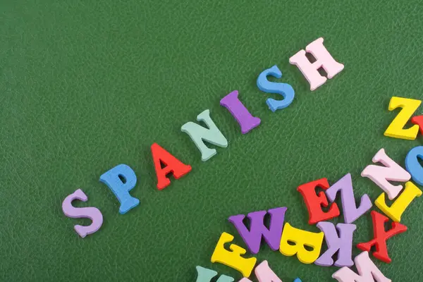 SPANISH word on green background composed from colorful abc alphabet block wooden letters, copy space for ad text. Learning english concept