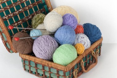 Yün, iğneler ve yün kazak için el yapımı örgü sepeti ahşap masa üzerinde konuşmacı ile Top