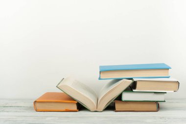 Açık kitap, ahşap masa üzerinde renkli ciltli kitap. Okula dönüş. Metin için yer kopyalayın. Eğitim iş kavramı