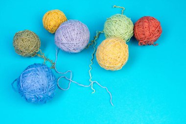 Mavi arka planda renkli iplik. Örgü örmek için yün derileri. Ahşap arka planda el yapımı örgü örmek için farklı renkte yün toplar ve reklam için kopya alanı