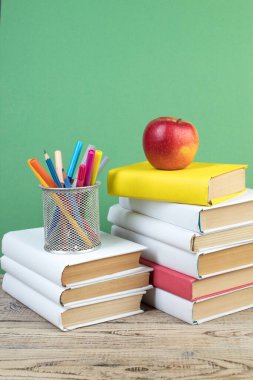 Kitaplar istifleniyor. Tahta masadaki kitaplar ve yeşil arka plan. Okula dönelim. Reklam metni için alanı kopyala
