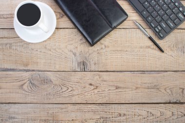 Bilgisayarlı ahşap ofis masası, kalem ve bir fincan kahve, bir sürü şey. Kopyalama alanı olan üst görünüm