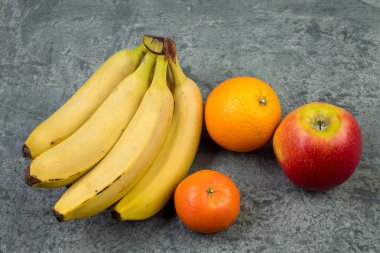 Meyveler. Bir biton arka planda muz, elma, portakal