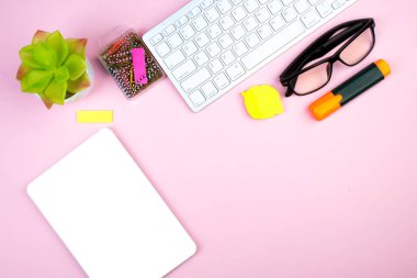 Bilgisayarlı pembe ofis masası, kalem ve bir fincan kahve, bir sürü şey. Kopyalama alanı olan üst görünüm