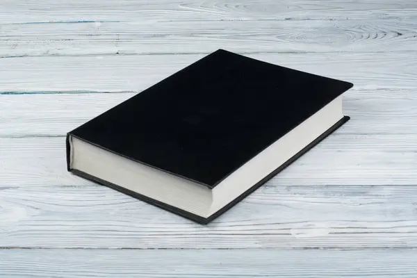 black book on a white wooden table