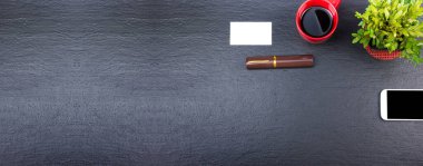 Bilgisayarlı, kalemli, kahveli, siyah ofis masası, bir sürü şey. Kopyalama alanı olan üst görünüm. Pankart