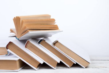 Açık kitaplar, ahşap masada ciltli renkli kitaplar. turuncu arka plan. Okula dönelim. Uzayı metin için kopyala. Eğitim sektörü kavramı