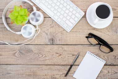 Bilgisayarlı ahşap ofis masası, kalem ve bir fincan kahve, bir sürü şey. Kopyalama alanı olan üst görünüm