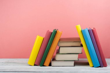 Kitap istifleme. Açık kitap, ahşap masa ve mavi arka plan üzerine ciltli kitaplar. Okula dönelim. Metin için alanı kopyala